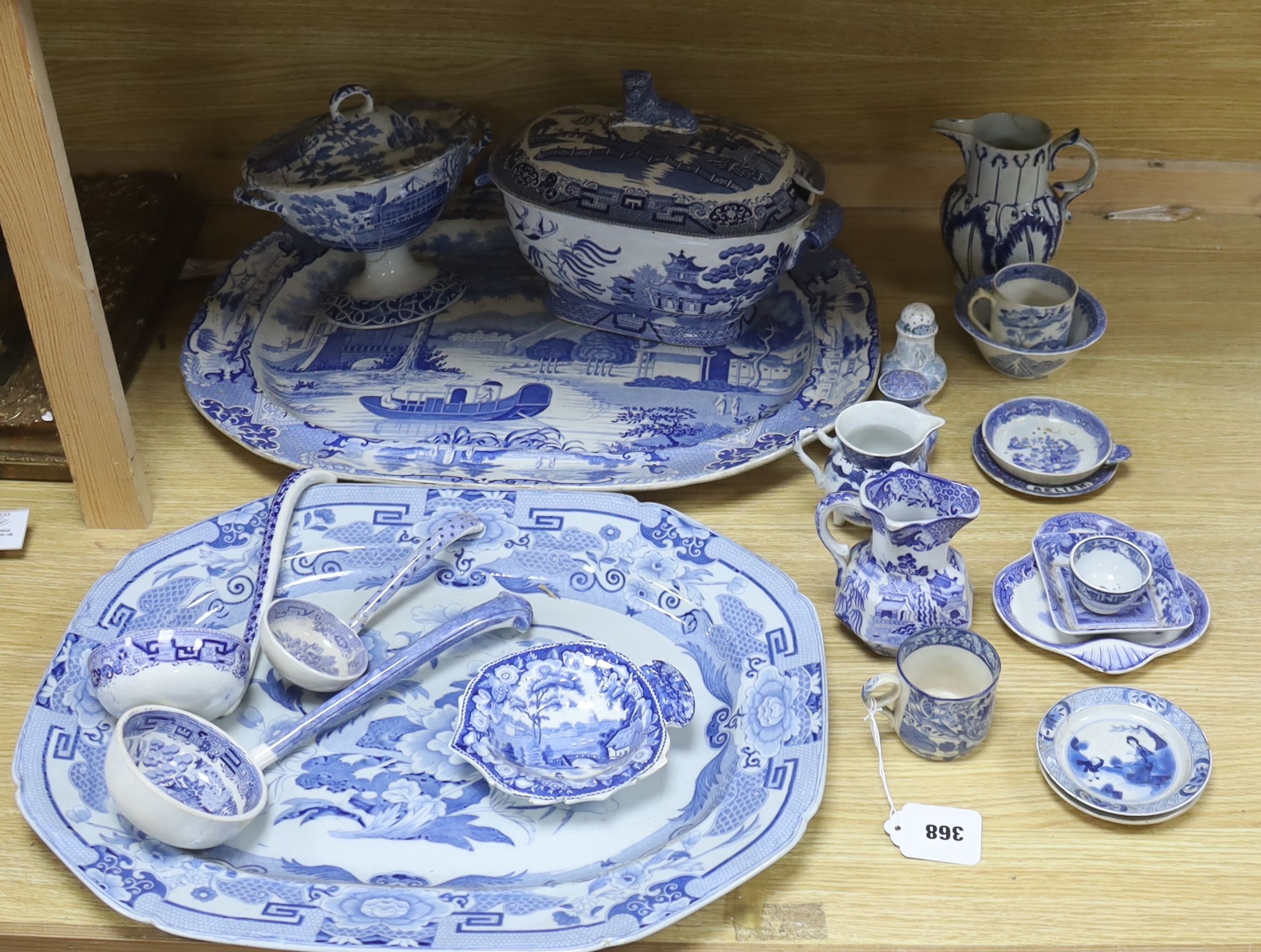 A group of 19th century blue and white pottery to include a chinoiserie pattern meat plate, 53.5 cm, a patent ironstone pheasant pattern dish, 47.5 cm, various tureens, dishes, ladles etc. a pearlware jug and two Chinese